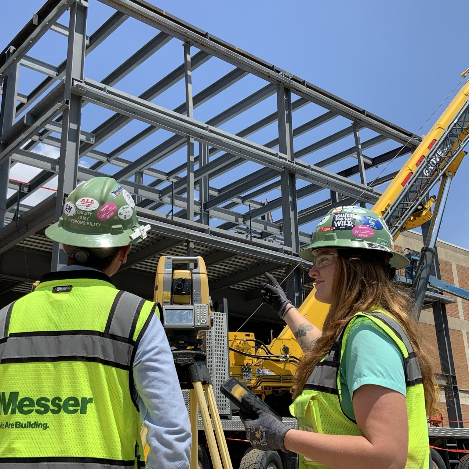 Messer Construction Co employees standing on a construction site in front of steel structure